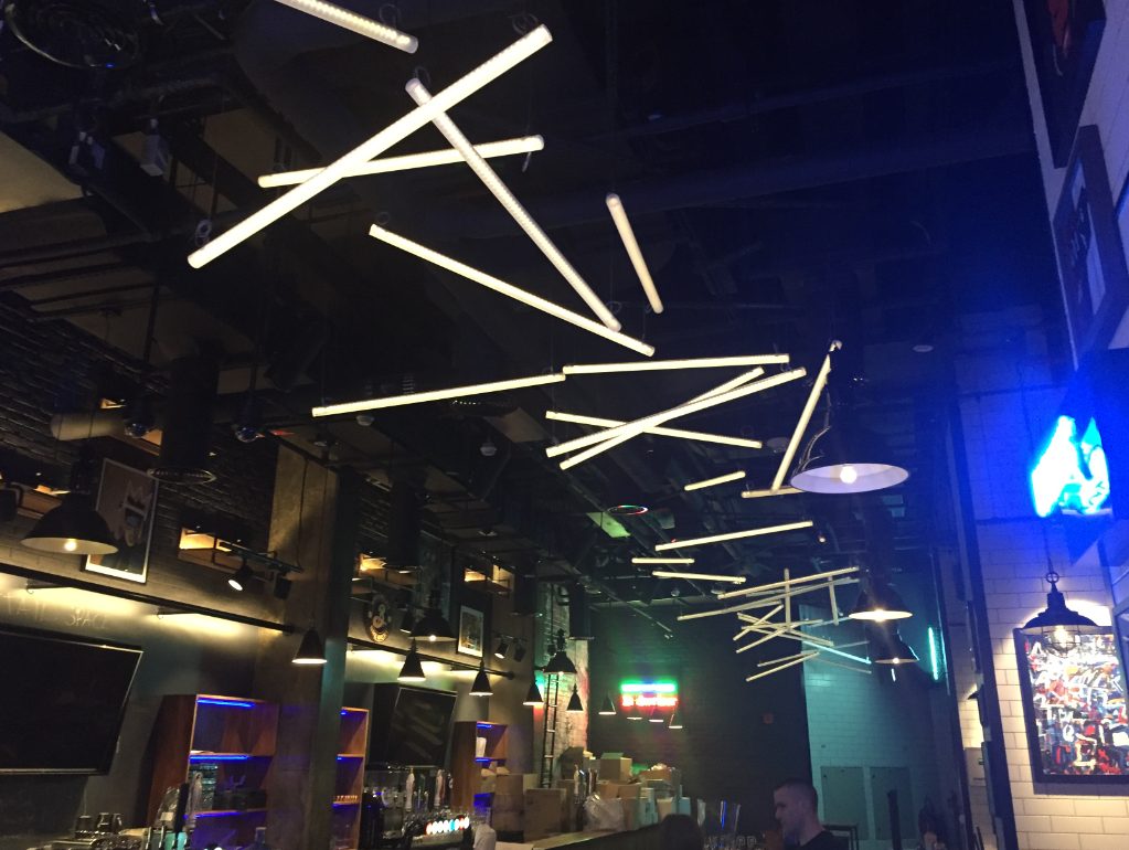 Custom sculptural linear-tube ceiling lighting at Black Tap